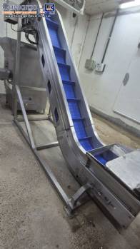 Inova Industrial inclined stainless steel conveyor belt with cleats.