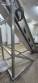 Inova Industrial inclined stainless steel conveyor belt with cleats.