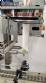 Label applicator machine with steam-operated shrink tunnel for sleeves.